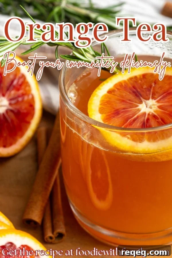 Orange tea in a mug with a slice of orange, a cinnamon stick, and a sprig of rosemary.