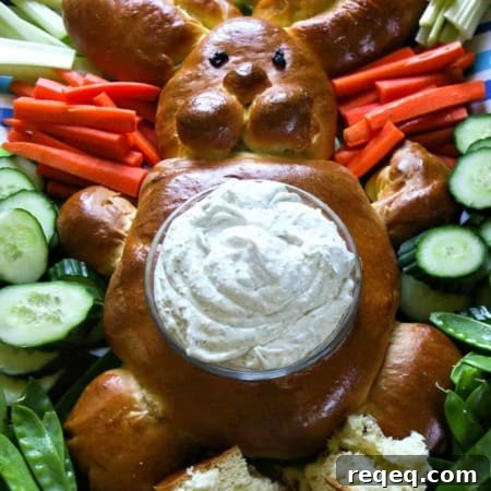 Easter Bunny Bread Recipe: How to Make Adorable Holiday Loaves 5 bread shaped like bunny, surrounded by raw cucumbers, bell peppers, broccoli, radishes, and carrots with their stems attached, belly of bread bunny lined with lettuce leaves and filled with dip