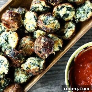 Cheesy Spinach Puffs in wooden serving dish, wooden bench, anthropologie nesting measuring cup with marinara sauce